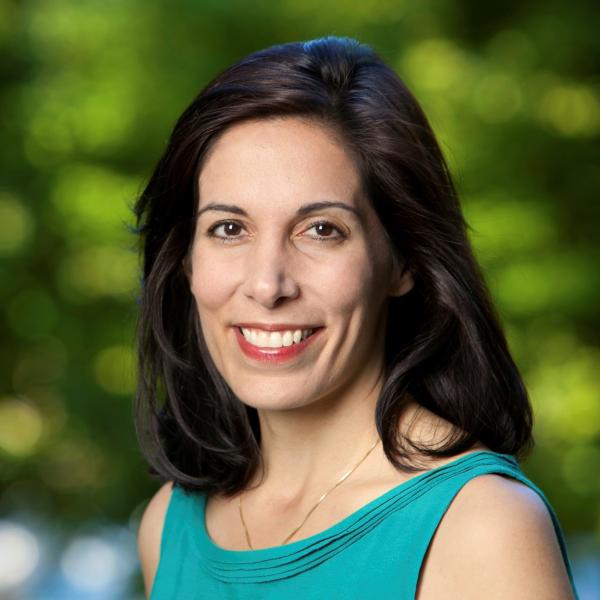 Woman in green shirt smiling with a green background